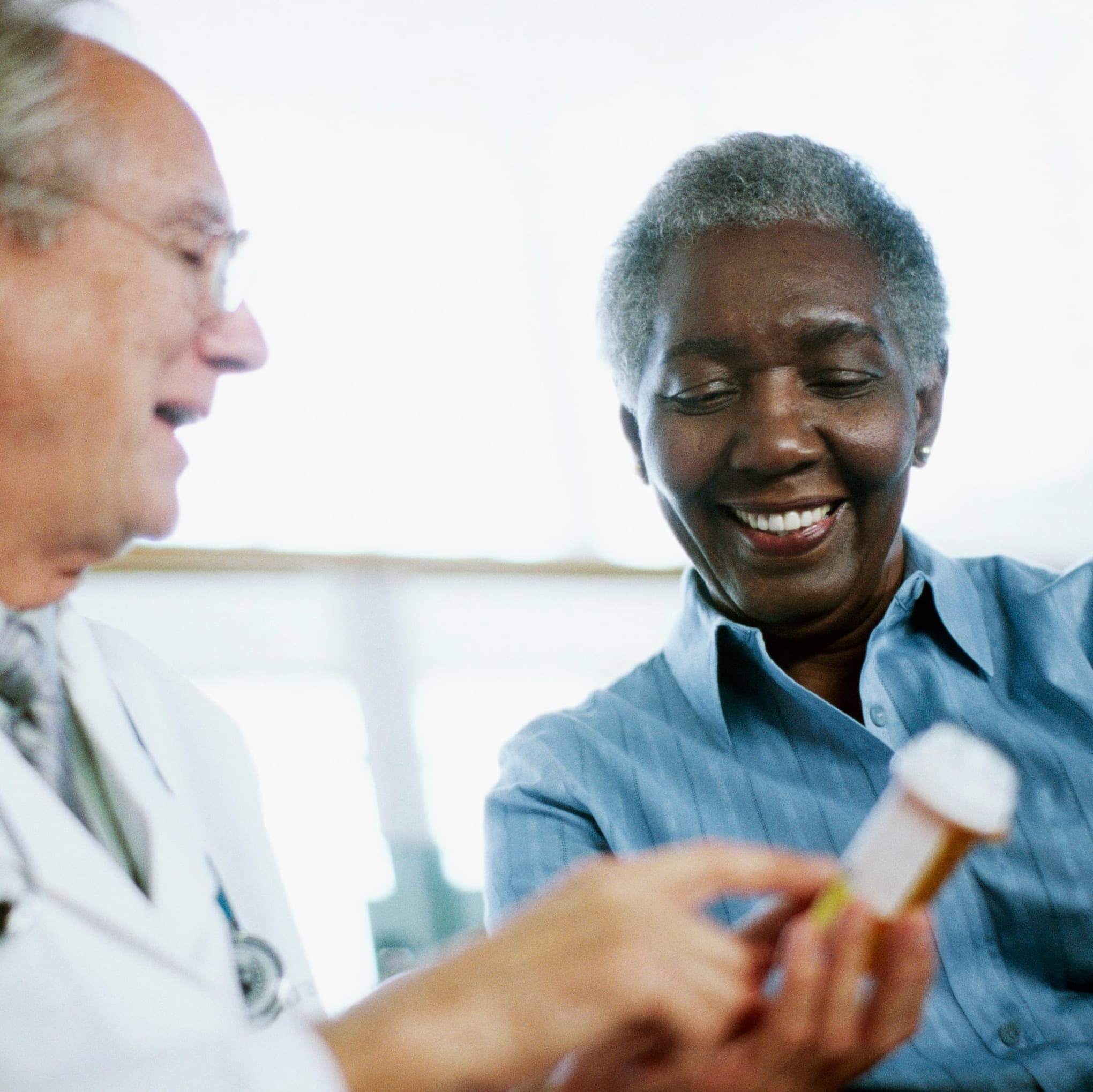 doctor and patient are looking at a medication bottle