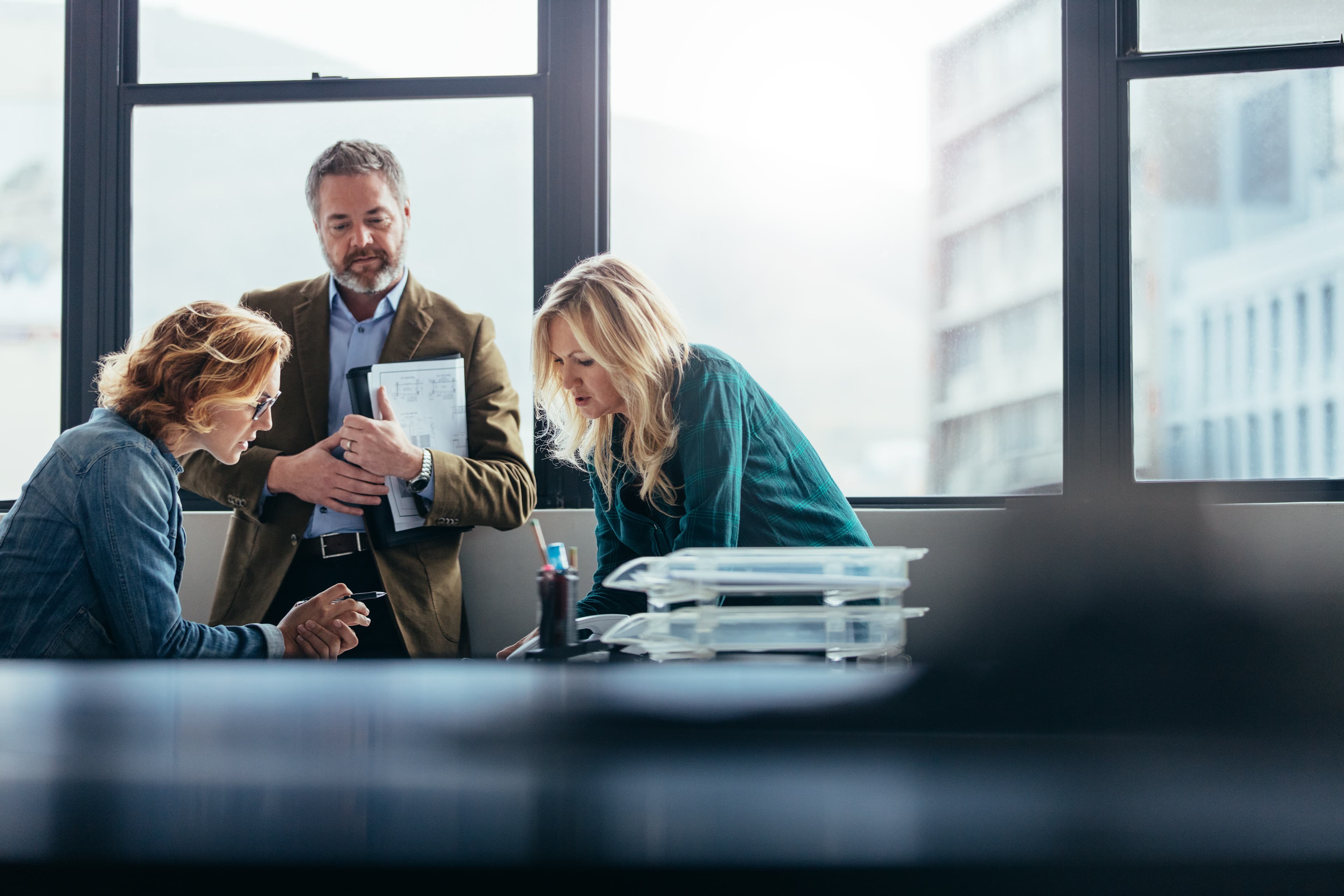 3 colleagues collaborating near window